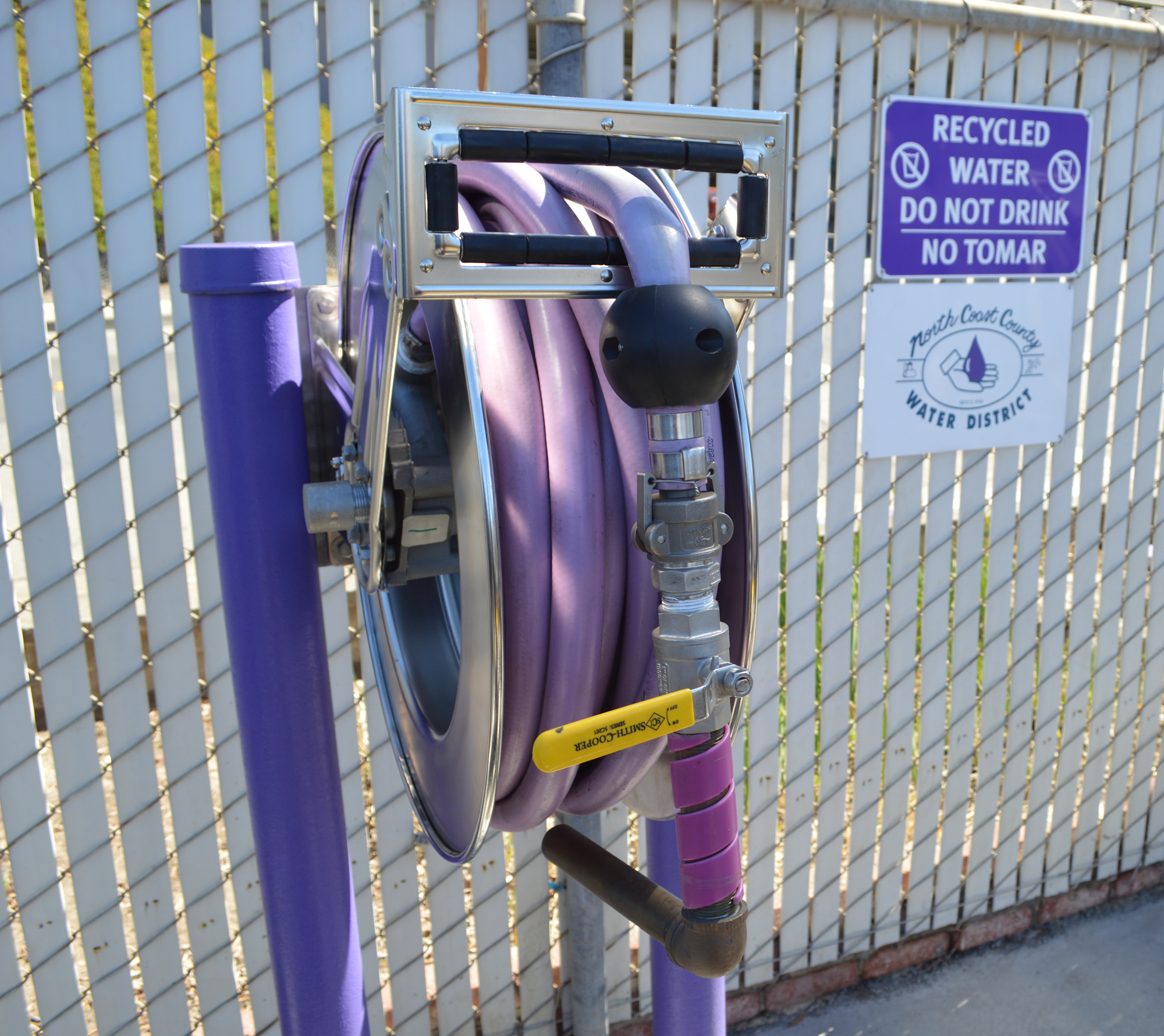 Purple hose reel for recycled water with a warning: "Do not drink."