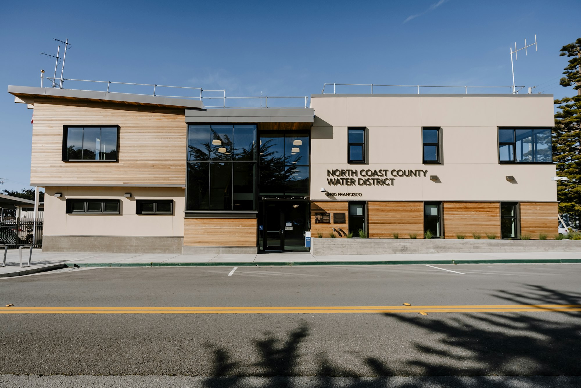 The image shows a modern building with wood and glass features, identified as the North Coast County Water District.