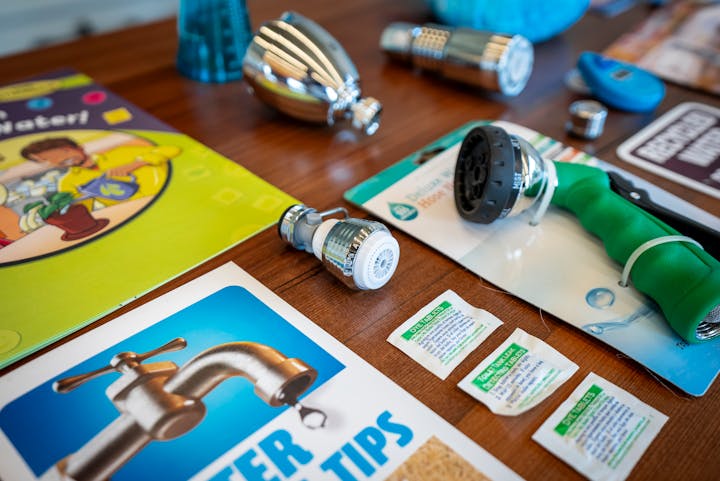 The image displays water-saving tools, tips, and educational materials, promoting efficient water use.