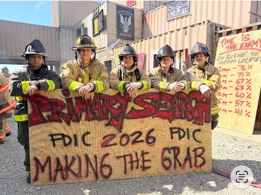 Five firefighters pose with a sign reading "PRIMARY SEARCH FDIC 2026 MAKING THE GRAB" at a training event.