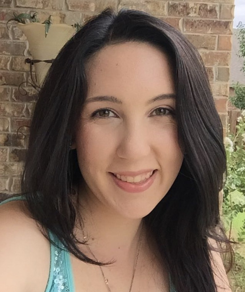 The image shows a woman smiling outdoors, with long dark hair and a teal top, against a brick background.