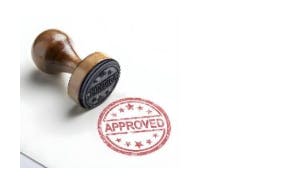 The image shows a wooden stamp with an "APPROVED" design beside it.