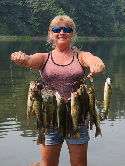 May contain: accessories, glasses, jewelry, necklace, animal, fish, sea life, person, fishing, leisure activities, outdoors, water, and trout