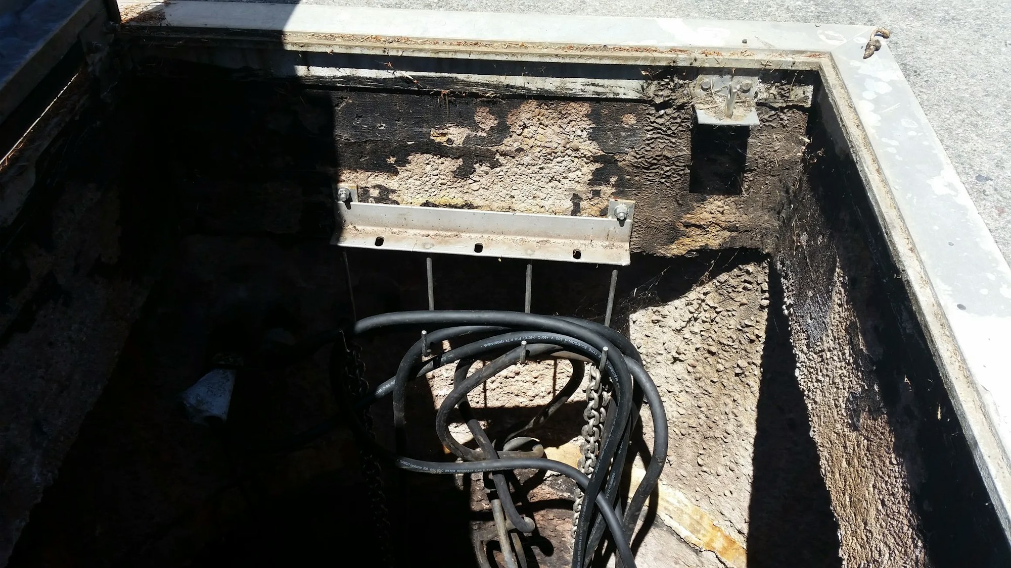 A deteriorated utility box with cables and damage visible.