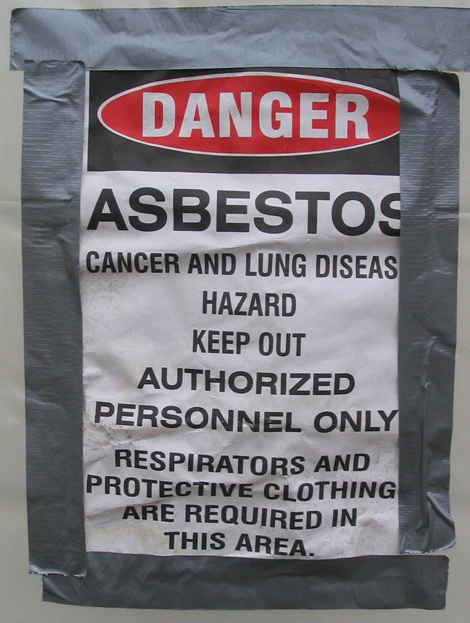 Danger sign warning about asbestos, indicating cancer and lung disease hazards. Authorized personnel only; protective gear required.