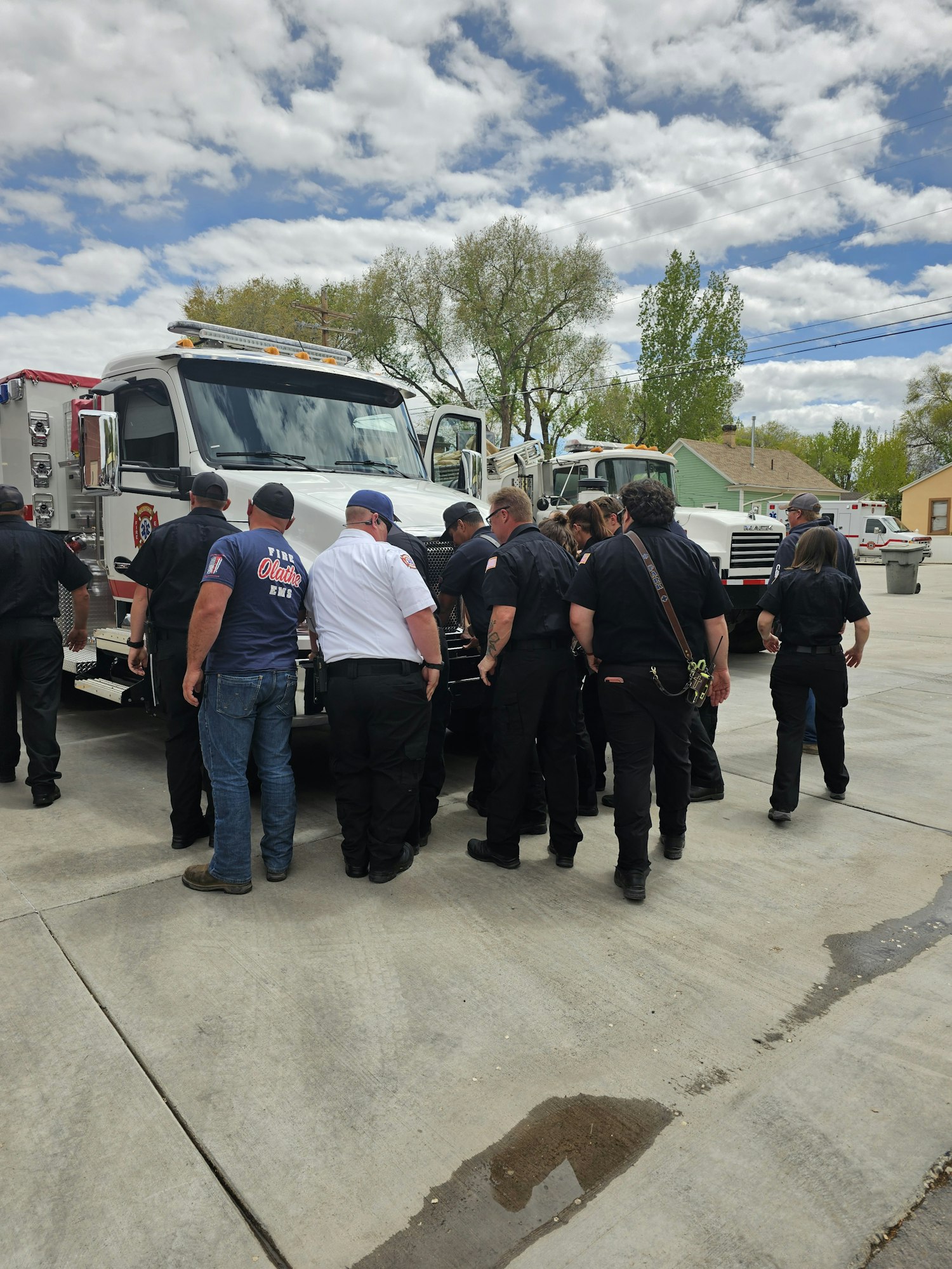 A group of people in a procession with a coffin near an ambulance. Image is rotated.