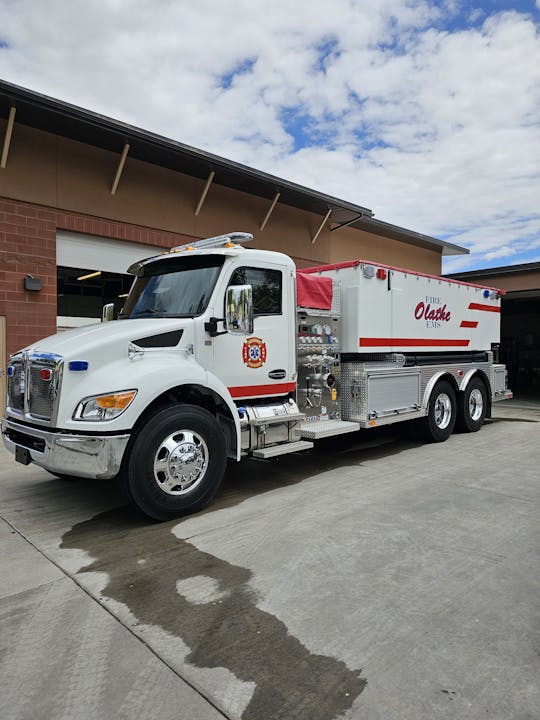 A firetruck parked outside a building with a clear sky above.