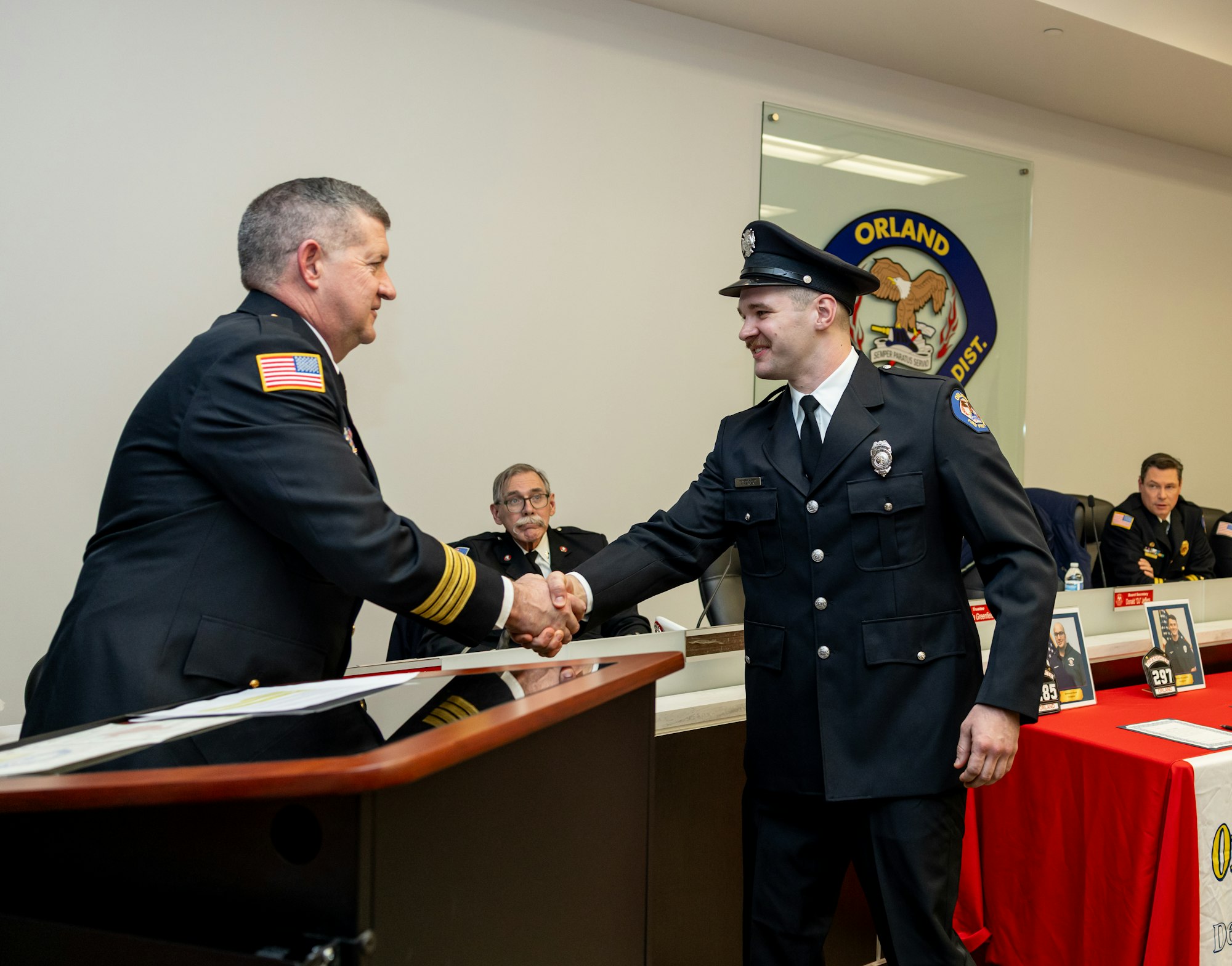 A ceremony where a police officer shakes hands with a superior, possibly during a promotion or award event.
