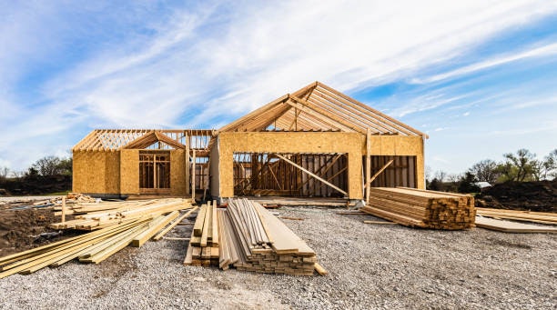 A house under construction with wooden frames and materials scattered around the site.