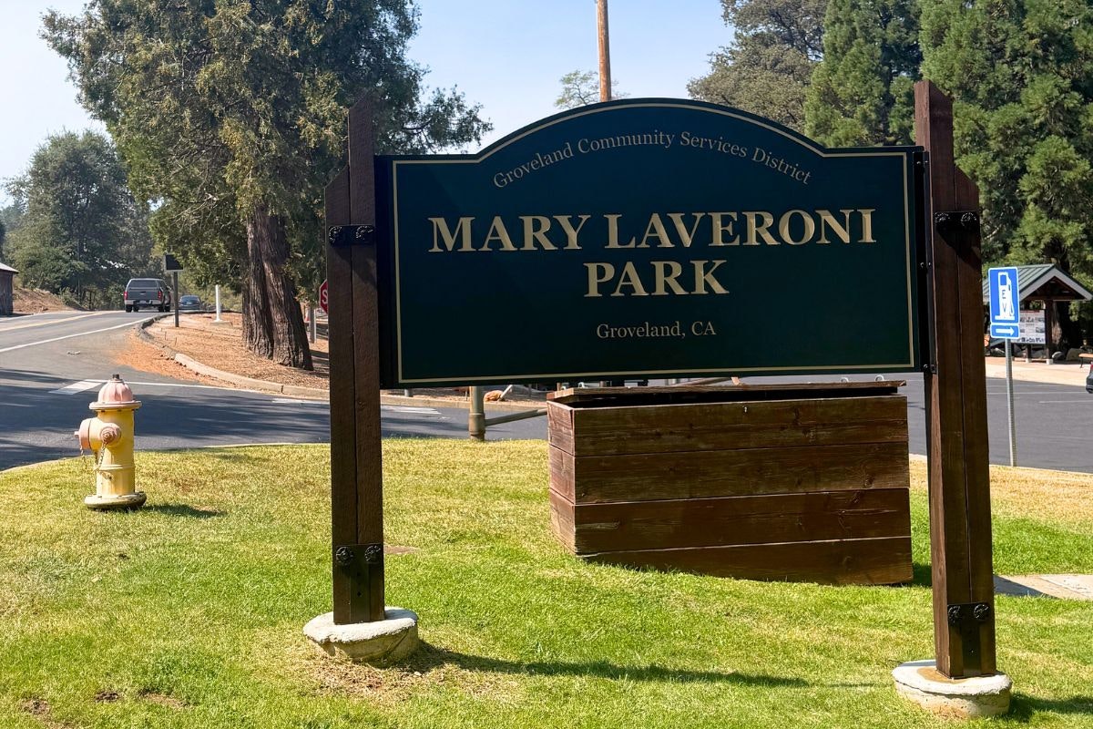The image shows a sign for Mary Laveroni Park located in Groveland, CA, with community service information nearby.