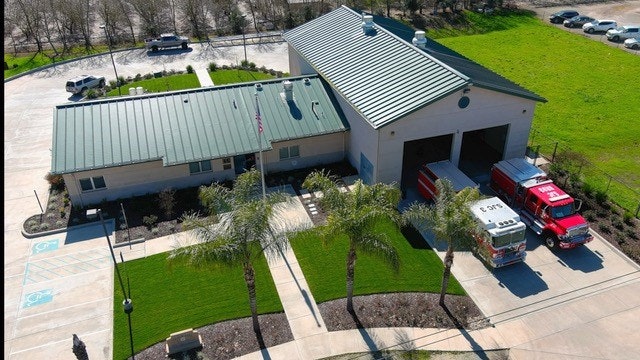 Aerial view of a fire station with fire trucks parked outside.