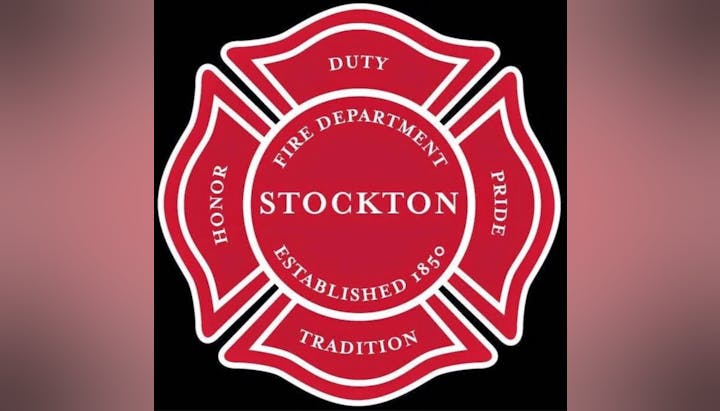 Red emblem of the Stockton Fire Department with words "Duty, Honor, Pride, Tradition," established 1850.