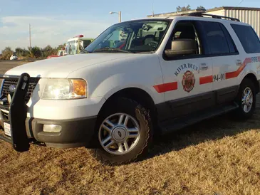 A white fire department SUV parked on grass.