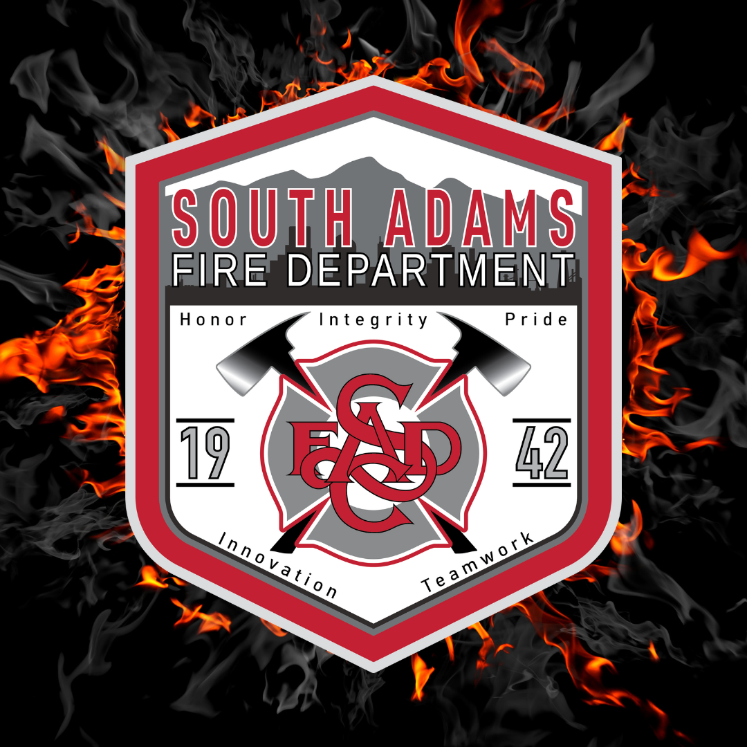 South Adams Fire Department badge with axes, flames, and words: Honor, Integrity, Pride, Innovation, Teamwork. Year: 1942.