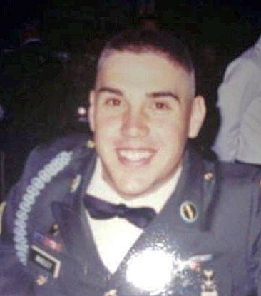 A person in military uniform smiling for the camera.