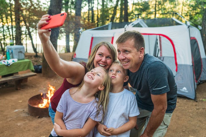Family taking a selfie at their campsite.