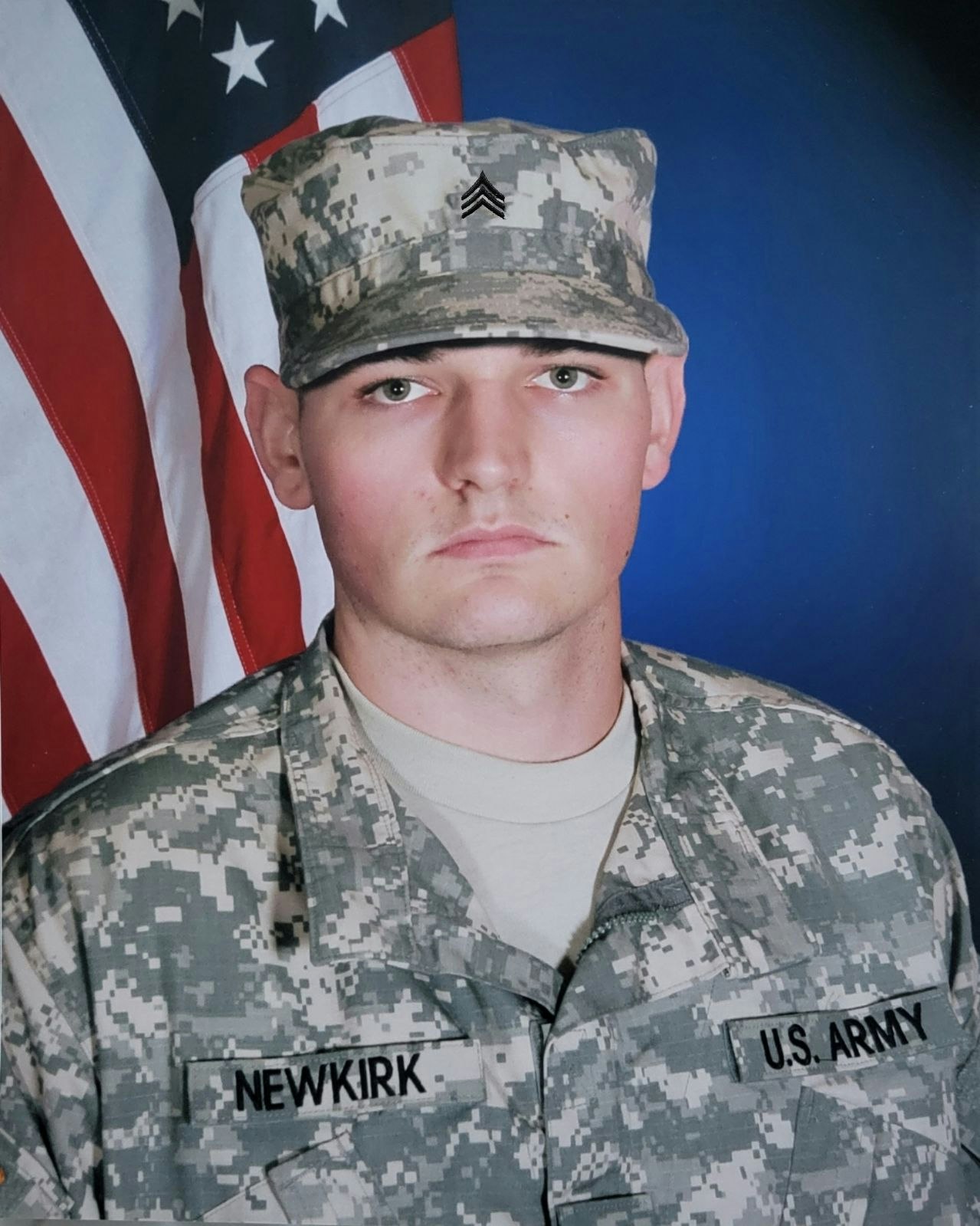 A person in U.S. Army uniform with a flag background.