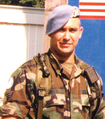 Person in military camouflage with a blue beret.