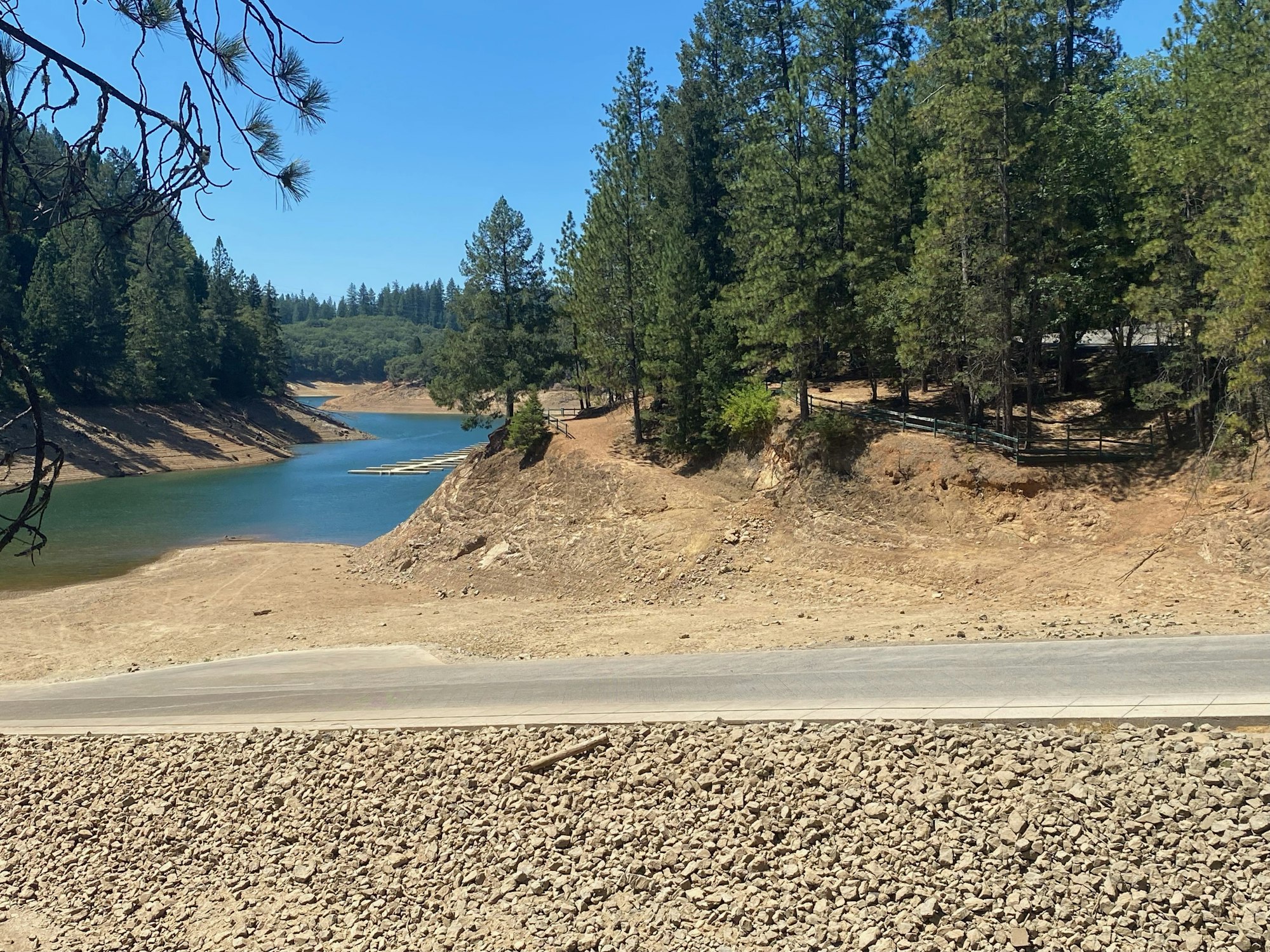 A river winding through a tree-lined landscape with a road and rocky terrain in the foreground.