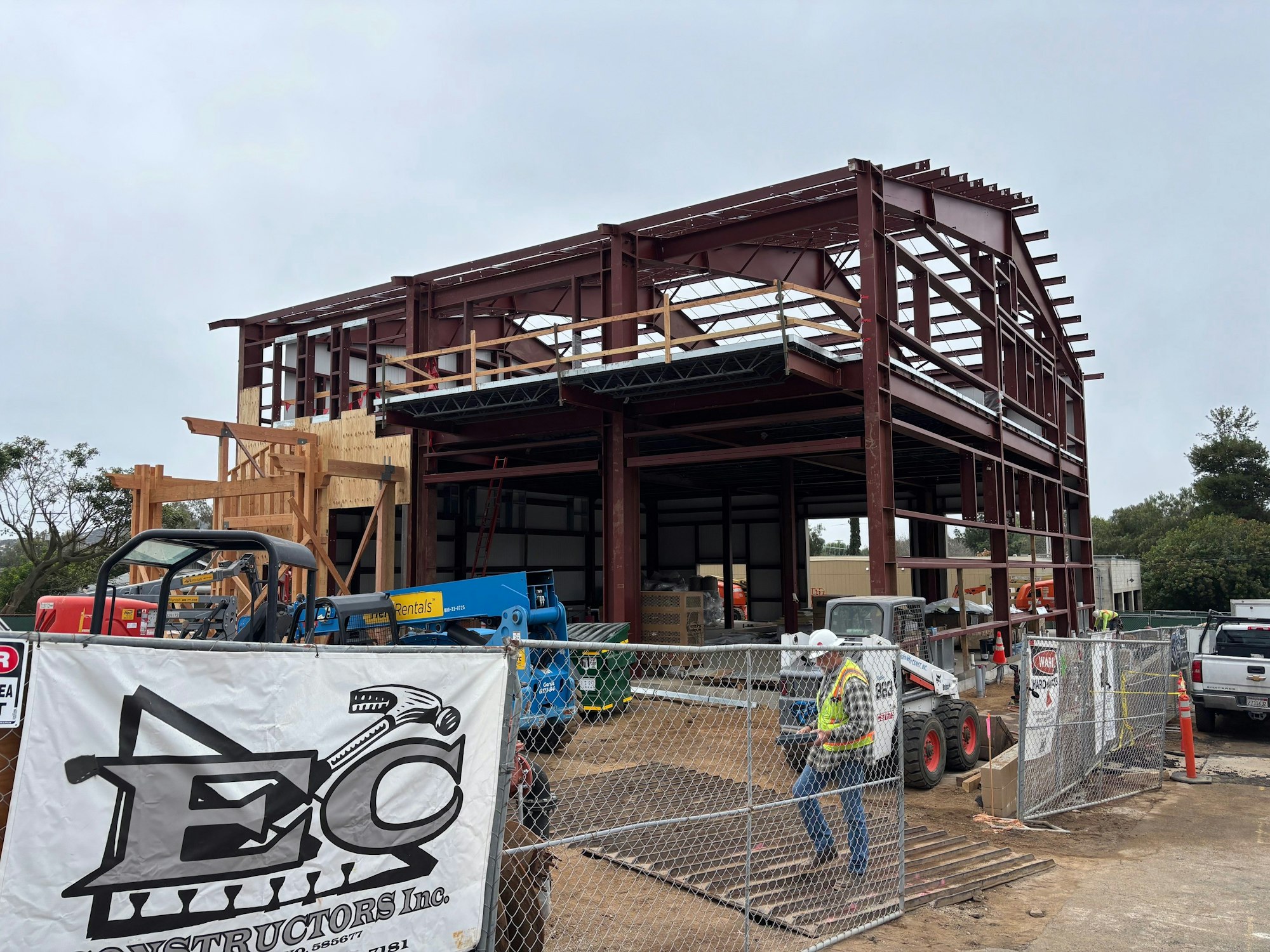 Station 18 (partially constructed with a steel framework, construction equipment, and workers on site) as of February 11, 2026