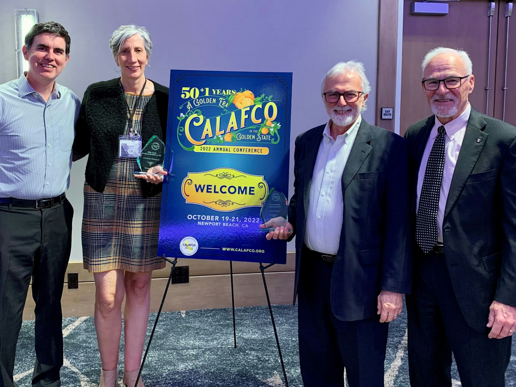 A group of four people poses with awards at the CALAFCO 2022 Annual Conference in Newport Beach, California.