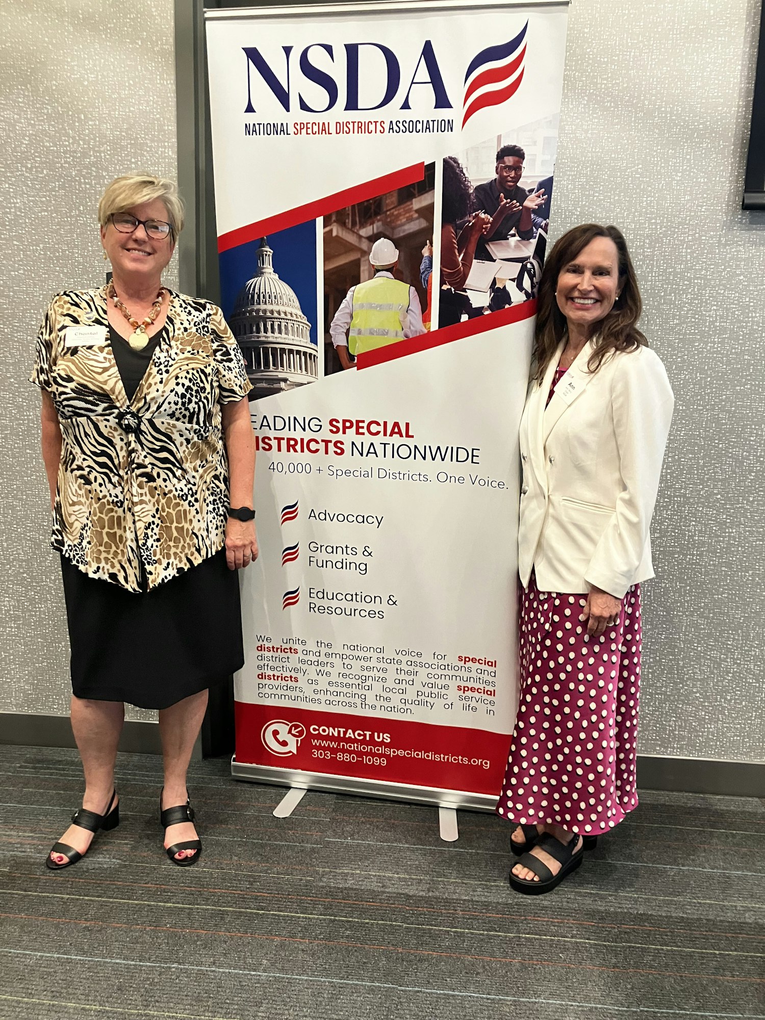 Two people standing beside a National Special Districts Association banner.