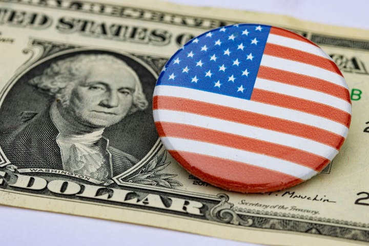 U.S. dollar bill with a button of the American flag on it.