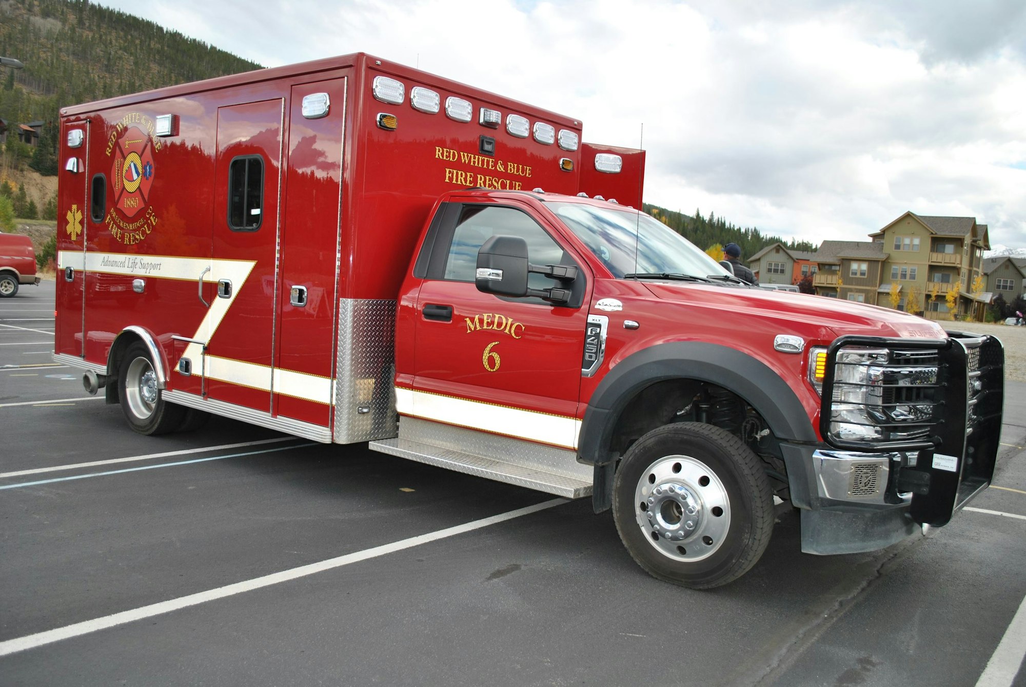 A red emergency medical services (EMS) ambulance parked in a lot.