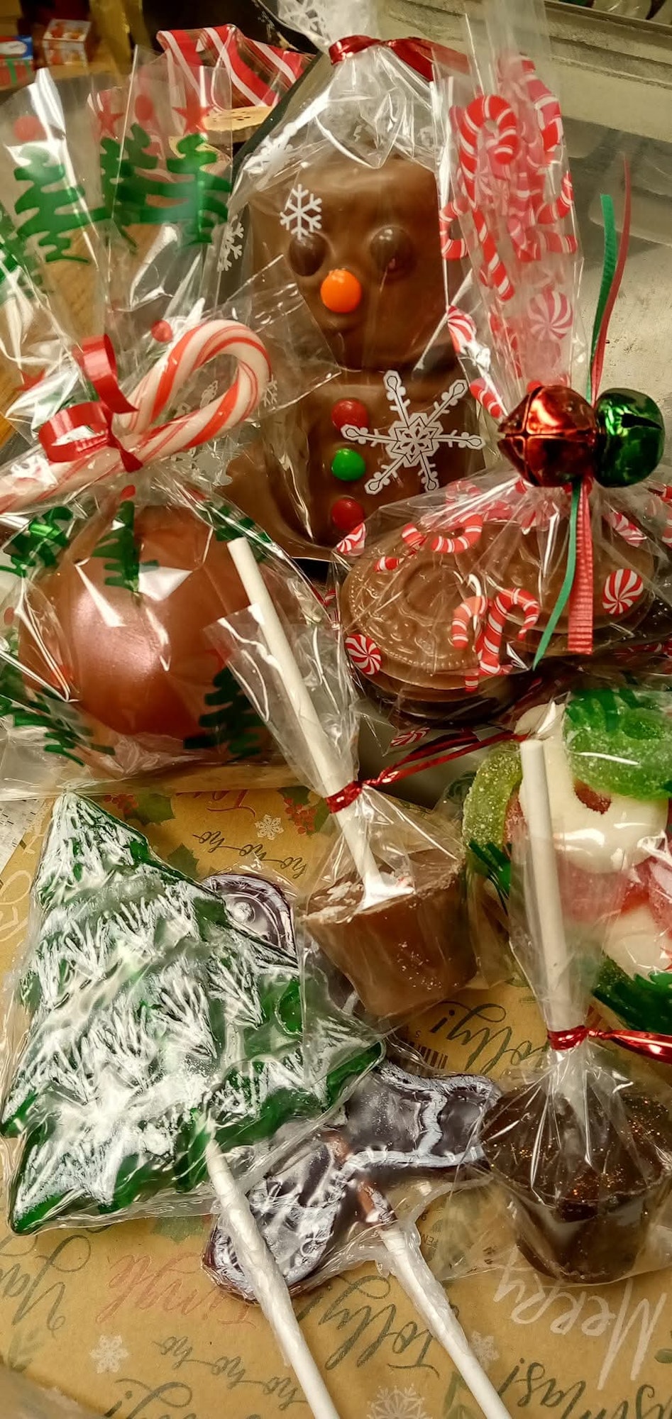 Assorted holiday-themed chocolates and candies wrapped in festive packaging.