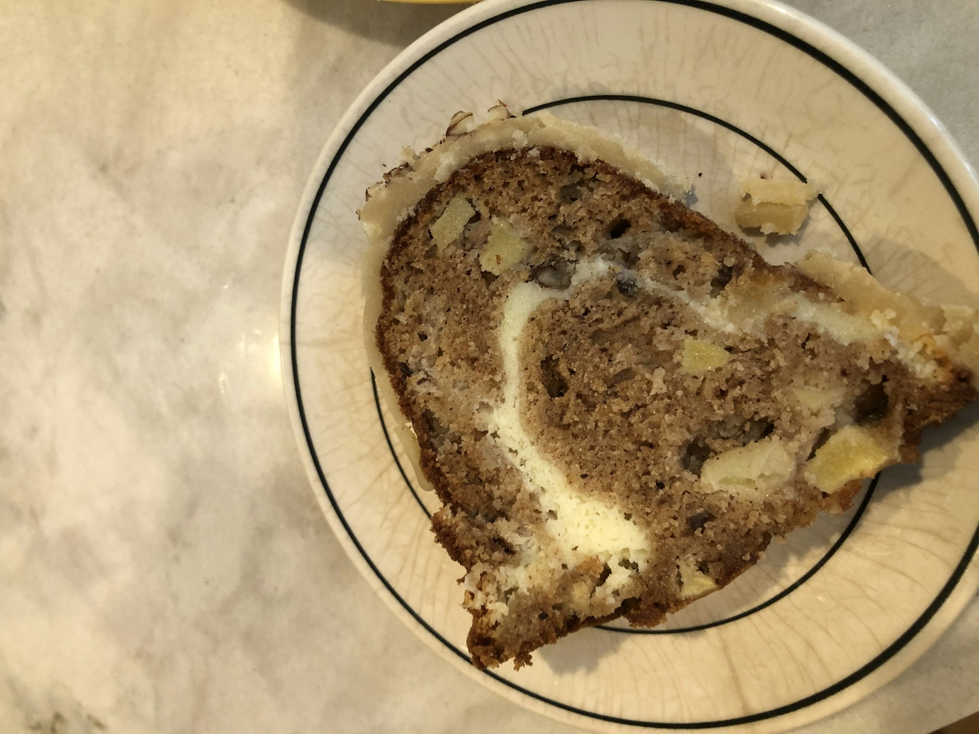 A slice of cake with nuts and fruit on a decorative plate.