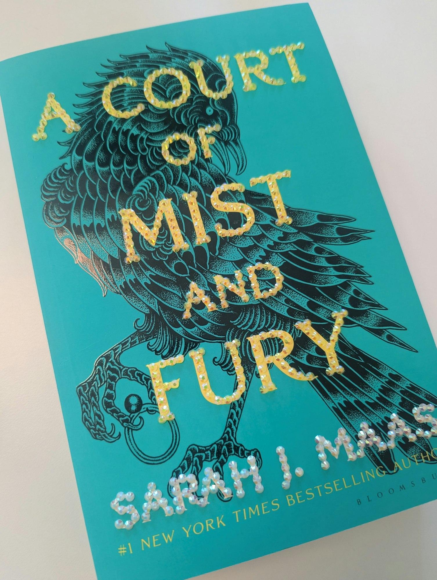 Book cover of "A Court of Mist and Fury" by Sarah J. Maas with a decorative bird.