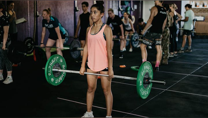 A group of people lifting weights in a gym.
