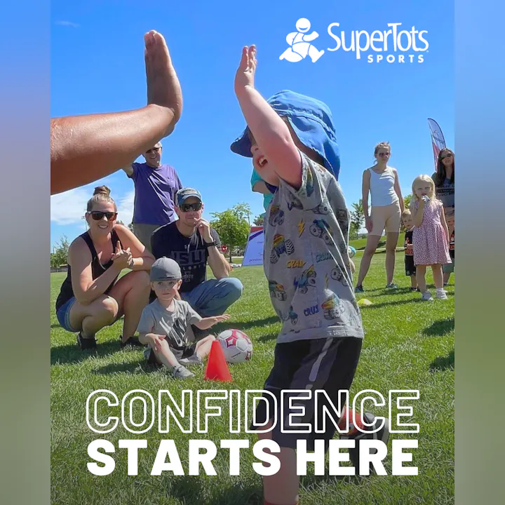 A child celebrates during a sports event, engaging with adults and peers, highlighting fun and confidence in a playful environment.