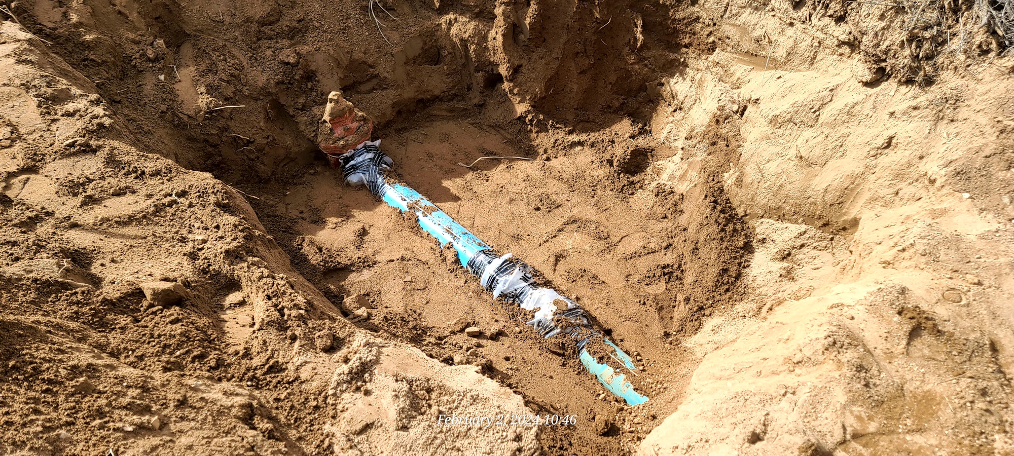 image of a water main with corrosion protection plastic wrapping