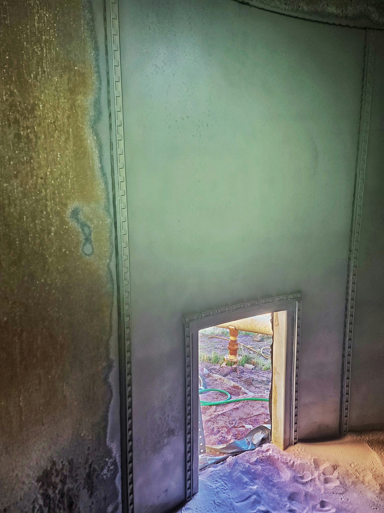 Interior of a water storage tank. Showing a comparison of an eroded wall and sandblasted wall.