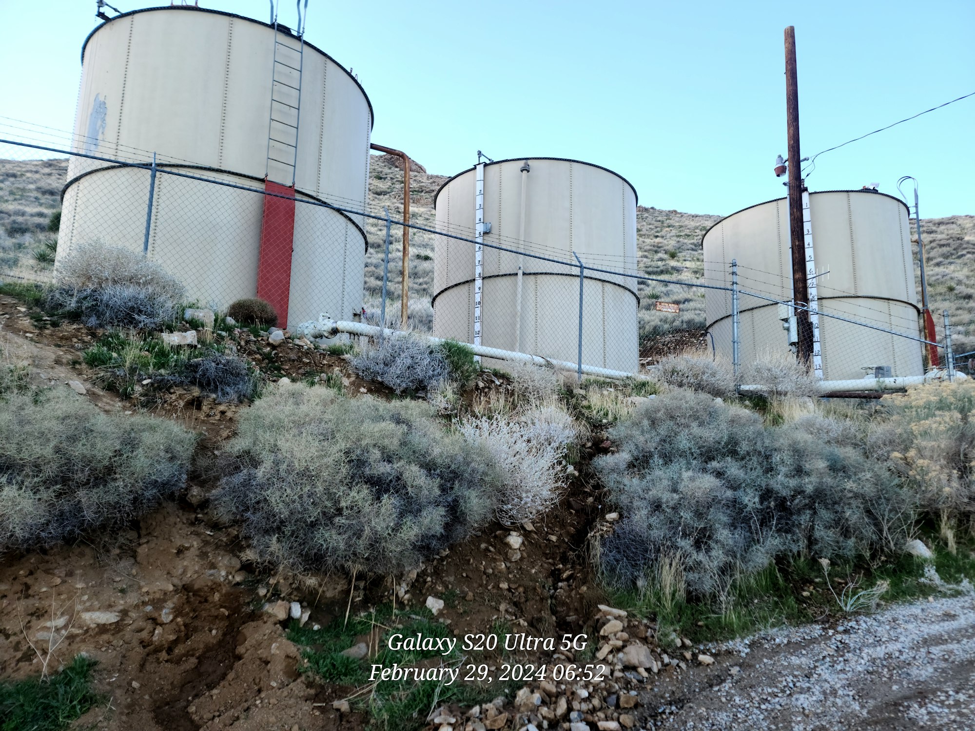 Image of three water storage tanks with a red security door to the ladder