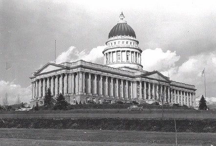 An old black-and-white photo of a grand capitol building with a dome and columns.