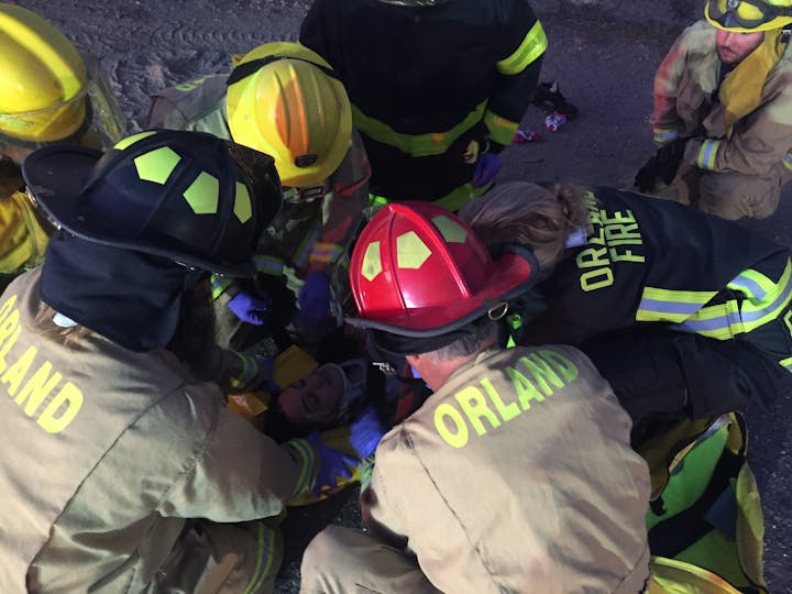 Firefighters are providing emergency care to an injured person at the scene.