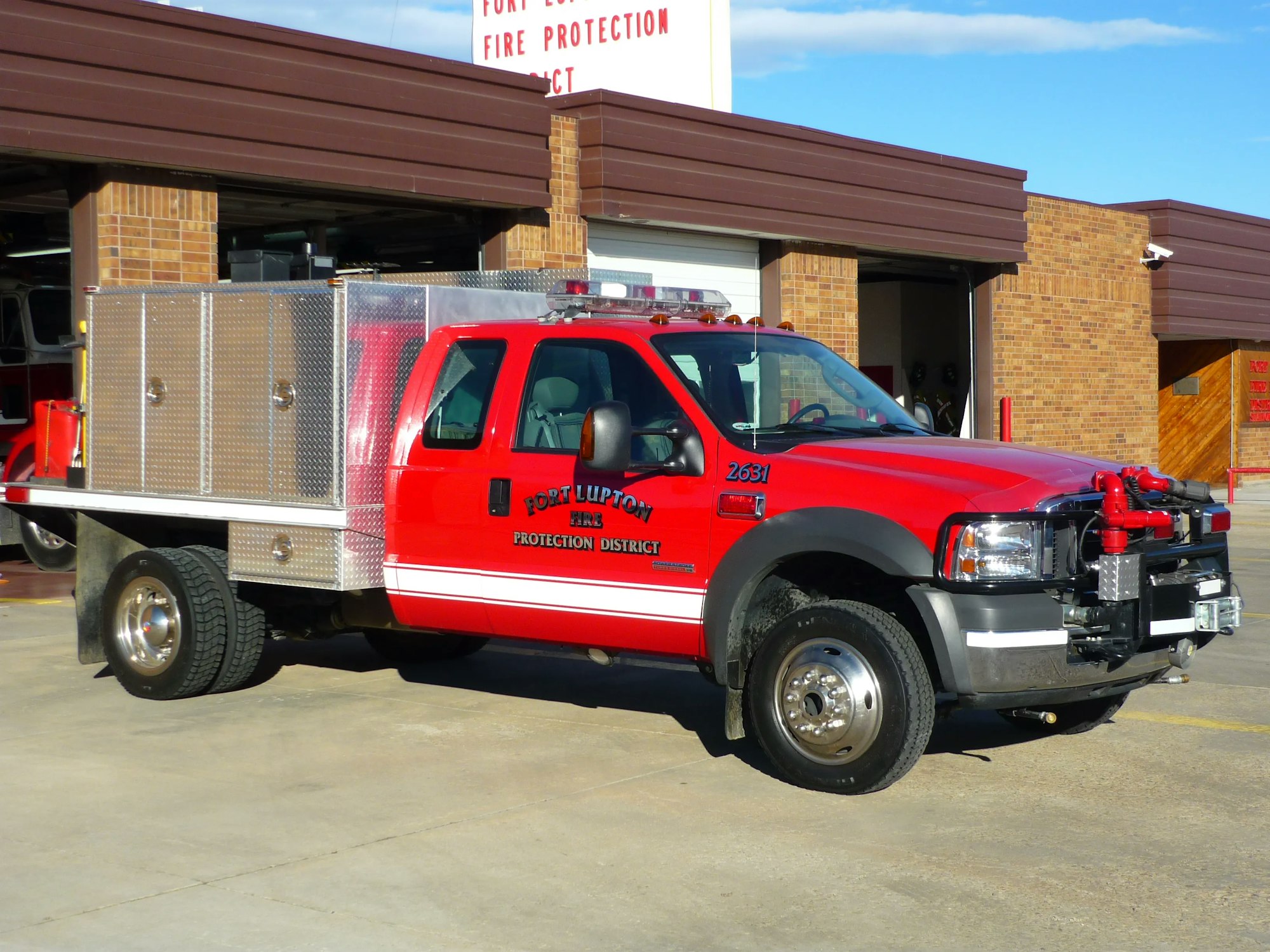 A red fire truck parked outside a fire station.