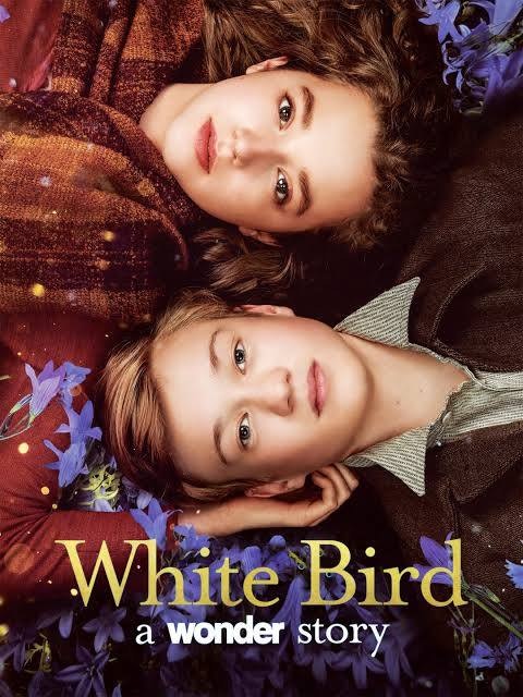 Two people lie in a field with flowers around them. Text reads "White Bird: A Wonder Story."