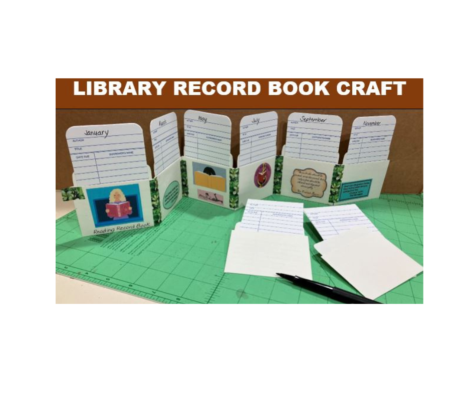 Craft project of a library record book with monthly dividers, paper, and pen on a cutting mat.