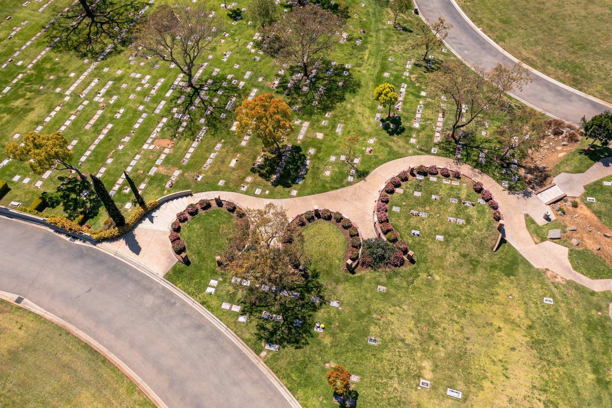 Aerial view of a cemetery with graves and a heart-shaped flower arrangement.