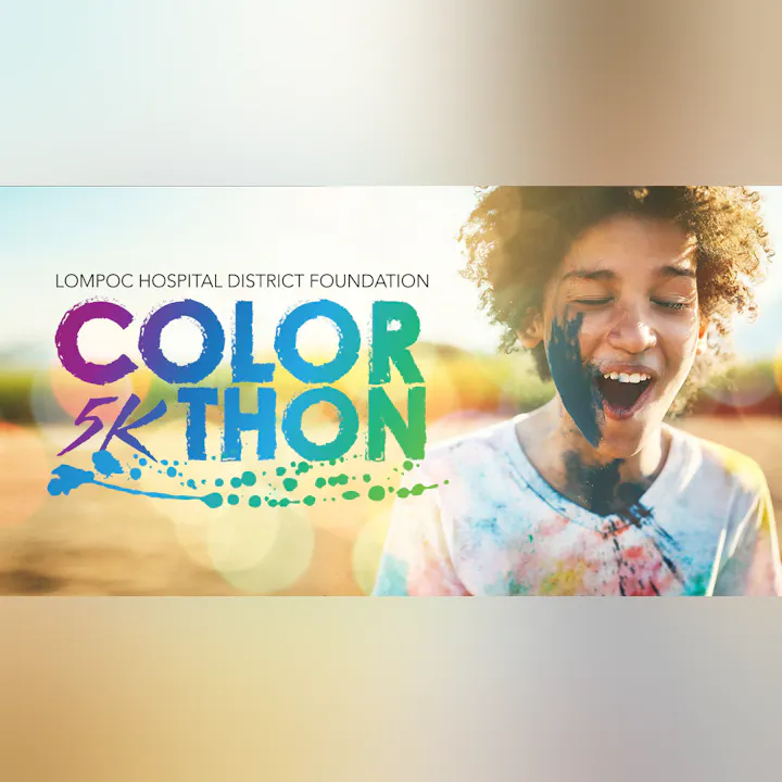 A joyful child covered in colorful powder participates in a fun run event called the "Color 5K Thon" for Lompoc Hospital District.