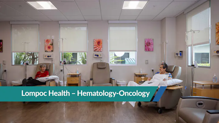 The image shows a hematology-oncology treatment room at Lompoc Health, featuring patients in comfortable chairs with IV setups.