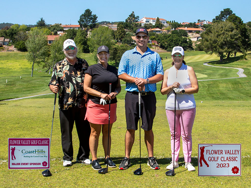 Four golfers pose on a course for the Flower Valley Golf Classic 2023, with sponsor signs visible nearby.