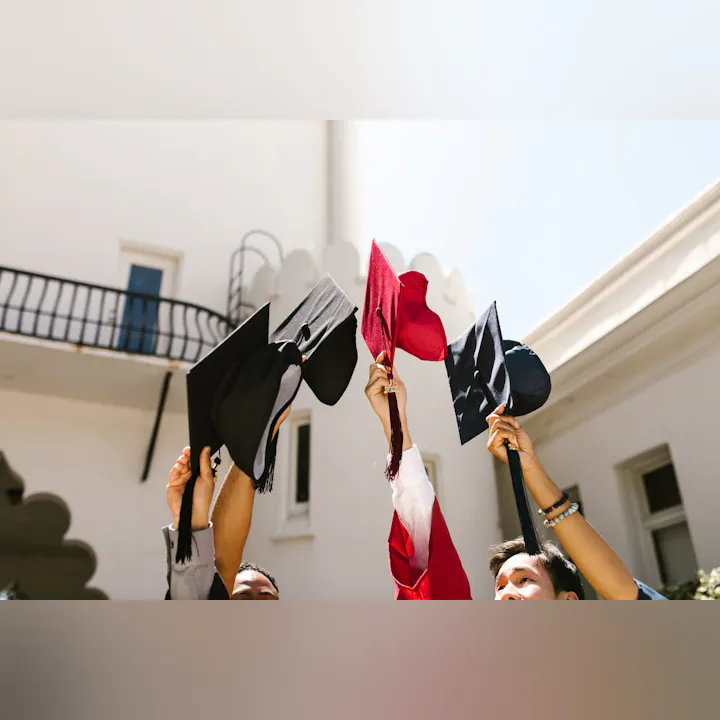 A group of graduates celebrating by throwing their caps in the air, showcasing joy and accomplishment.