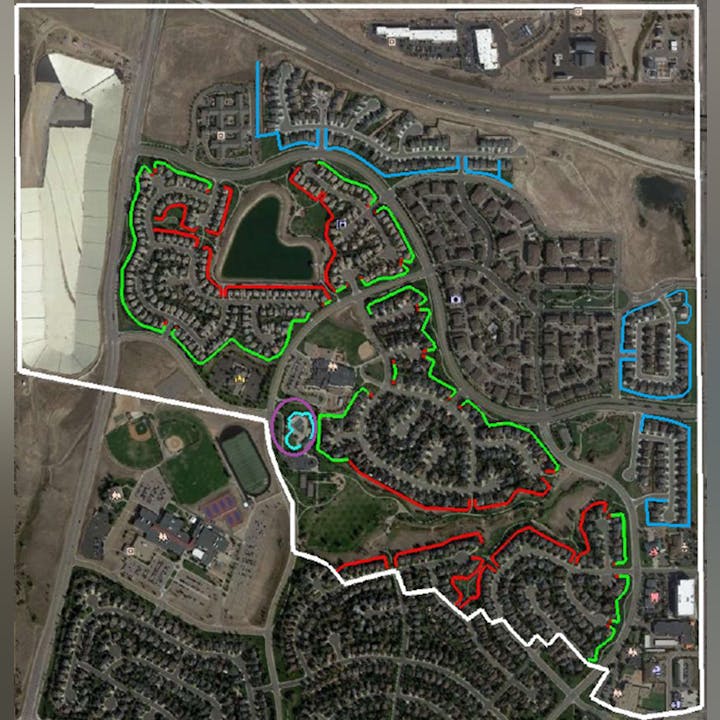 Aerial view of a neighborhood with various colored lines possibly indicating routes or boundaries.