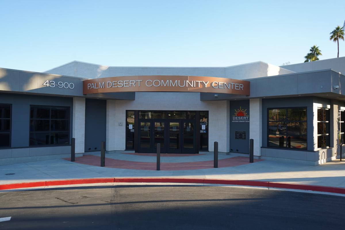 The image shows the entrance of the Palm Desert Community Center, featuring modern architecture and signage.