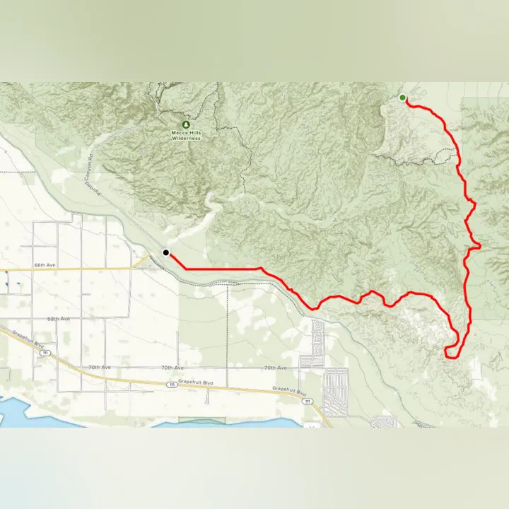 The image shows a map with a highlighted red trail route through mountainous terrain, near Mecca Hills Wilderness.