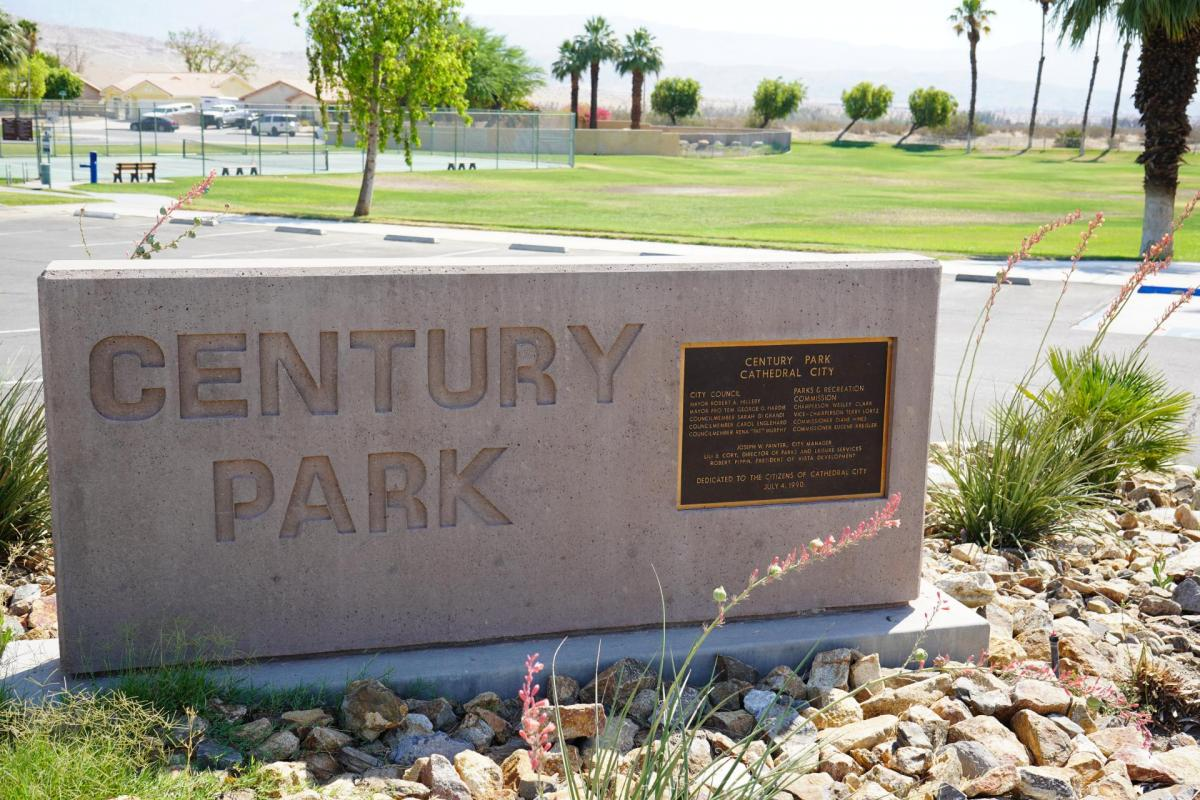 The image shows a stone sign for Century Park in Cathedral City, with a plaque dedicated to the citizens from July 4, 1904.